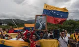 Mensen demonstreren tegen de inmenging van president Trump in Venezuela, op de Simón Bolívar-grensbrug tussen Venezuela en Colombia. 