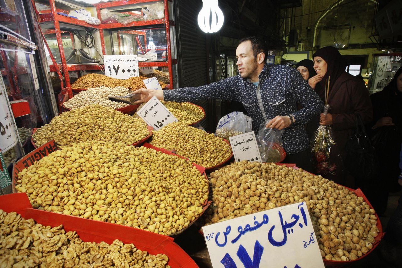 Een Iraanse marktkoopman probeert zijn pistachenoten aan de man te brengen in Teheran op 19 januari 2016.