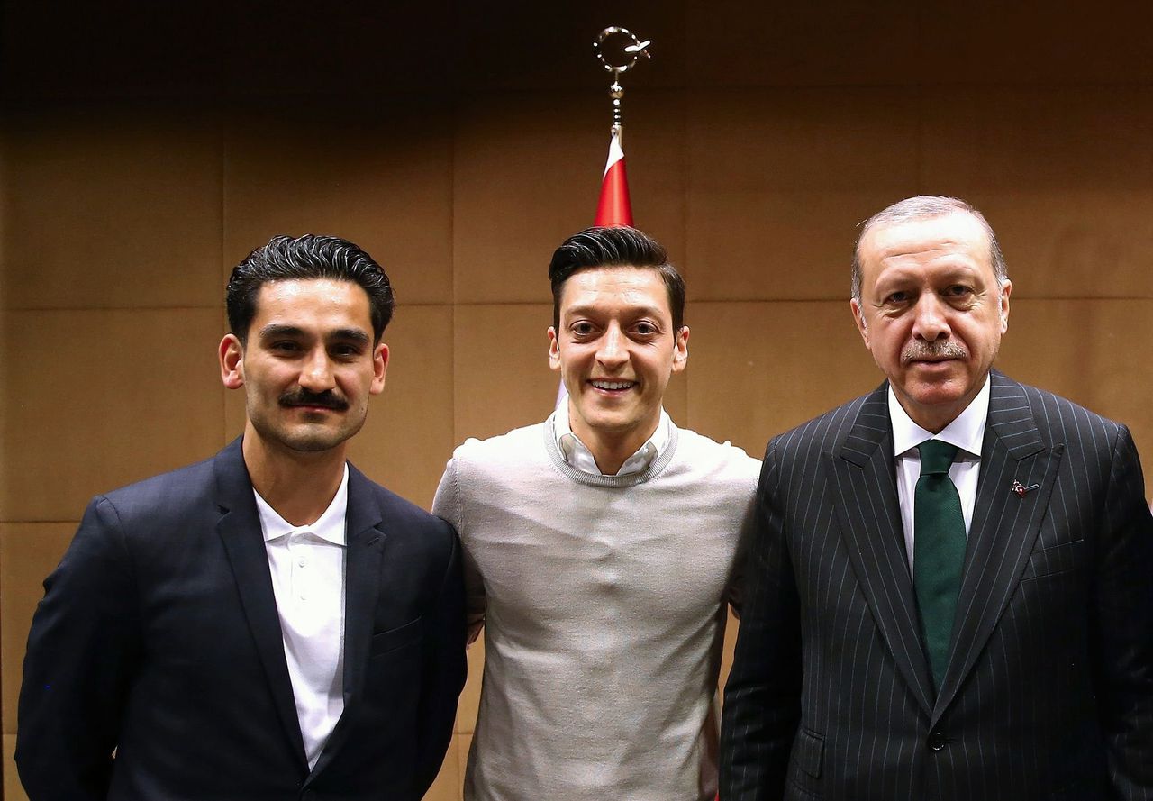 De foto van de Duitse voetballers Gundogan (L) en Özil (M) met de Turkse president Erdogan.