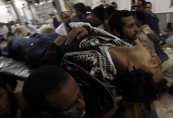 Anti-government demonstrators carry an injured man at a makeshift medical triage station at Tahrir square in Cairo February 2, 2011. Backers of President Hosni Mubarak, throwing petrol bombs, wielding sticks and charging on camels and horses, attacked protesters in Cairo on Wednesday after the army told reformists demanding the president quit to go home. REUTERS/Amr Abdallah Dalsh (EGYPT - Tags: CIVIL UNREST POLITICS IMAGES OF THE DAY)