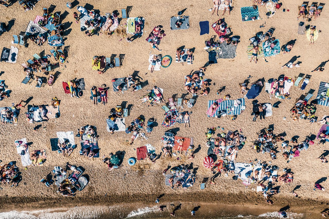 Een vol strand midden in de corona-pandemie.