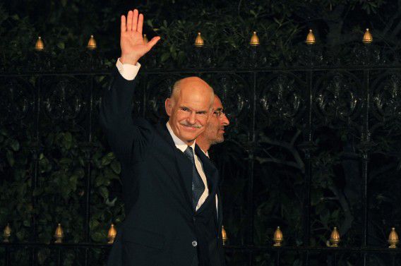 Greek Prime Minister George Papandreou greets reporters while arriving for his meeting with the Greek President in Athens on November 9, 2011. Papandreou pledged his support for his yet-to-be named successor on November 9 as he formally stepped down as leader of the debt-wracked country. AFP PHOTO / LOUISA GOULIAMAKI