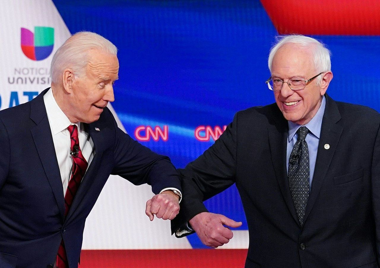 Biden (l) en Sanders (r) begroeten elkaar voorafgaand aan een debat op 15 maart.