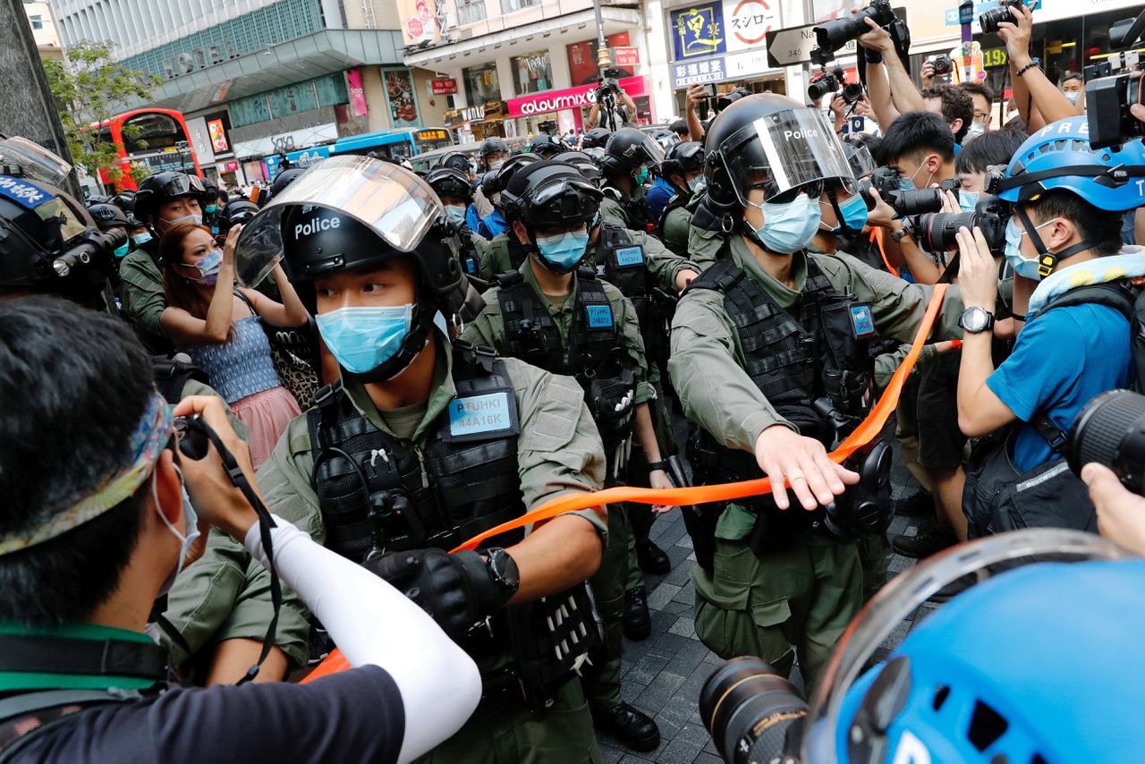 De oproeppolitie grijpt in tijdens een grootschalige demonstratie in Hongkong zondag.