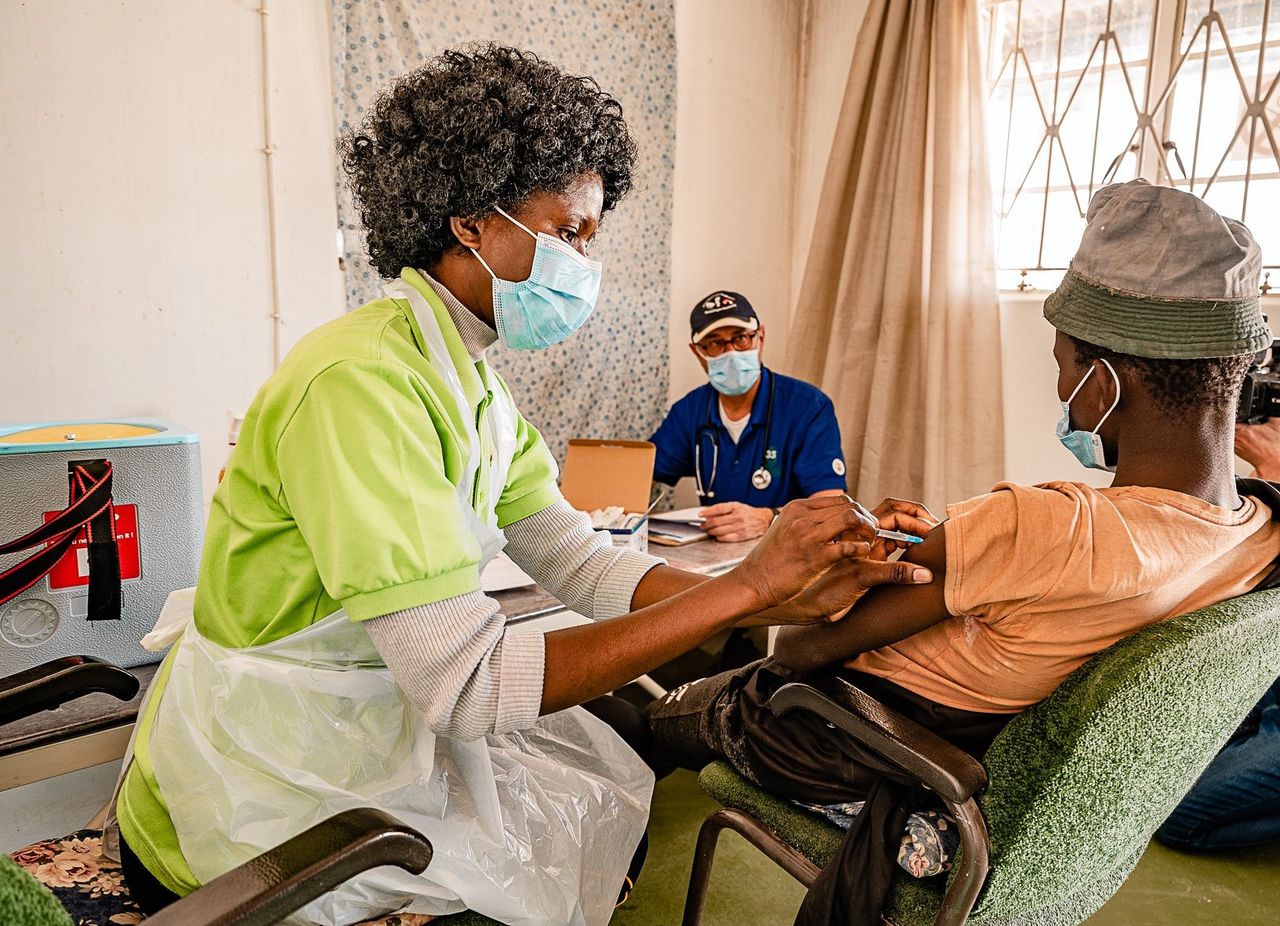 Huisarts Jan Peter Feenstra, met pet en mondkapje, tijdens het vaccineren in het oosten van Namibië.