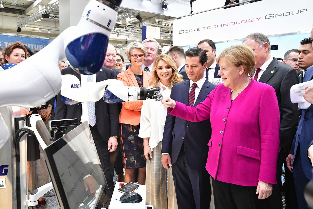 De Duitse bondskanselier Angela Merkel geeft een robot een 'boks' op een technologiebeurs in Hannover.