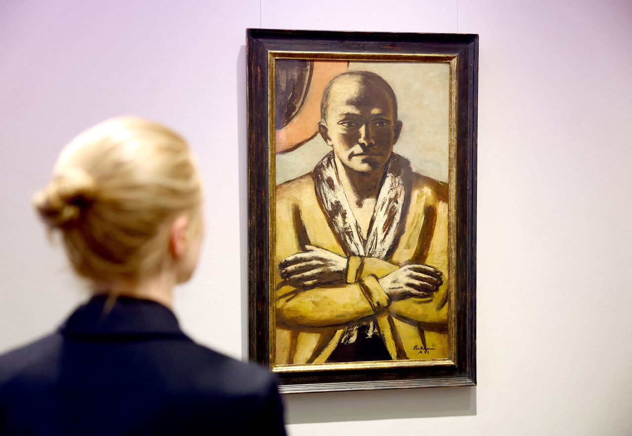 Een vrouw kijkt naar Beckmanns 'Zelfportret in geel-roze'. Het werk werd donderdag in Berlijn geveild voor 23,3 miljoen euro.