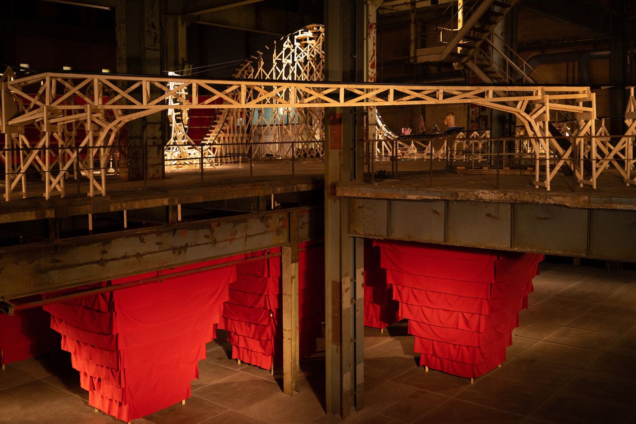 Het acht meter hoge kunstwerk ‘The Savage’ van Oscar Peters. Eronder staat een labyrint van schuddende rode zuilen.