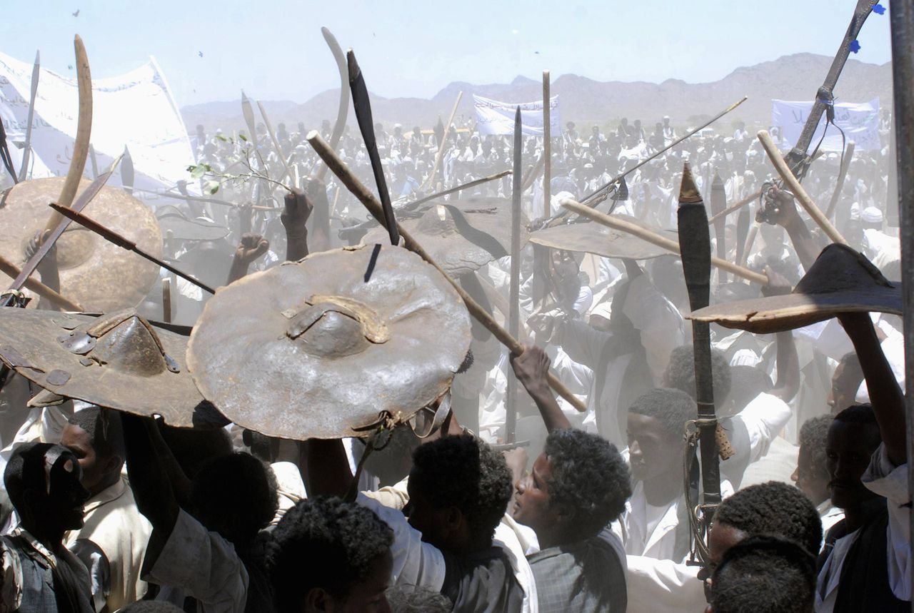 Supporters carry swords and animal skin "draqh" shields as they welcome Sudan's President Omar Al Bashir during his visit to Osaef town in Sudan's Red Sea state June 20, 2011. REUTERS/Stringer (SUDAN - Tags: POLITICS SOCIETY)