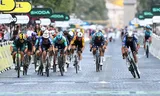 Met een uiterste krachtsinspanning blijft Mathieu van der Poel (rechts) uit de greep van het sprintende peloton en wint hij de slotrit van de Tour.