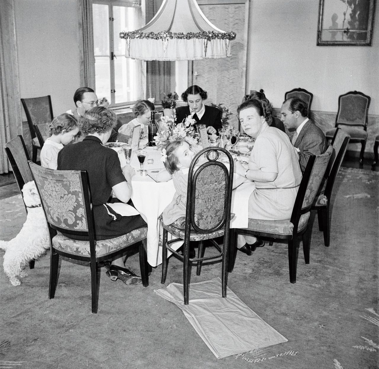 Prinses Juliana, prins Bernhard, hun dochters en personeelsleden aan de eettafel in Paleis Soestdijk, omstreeks 1947.