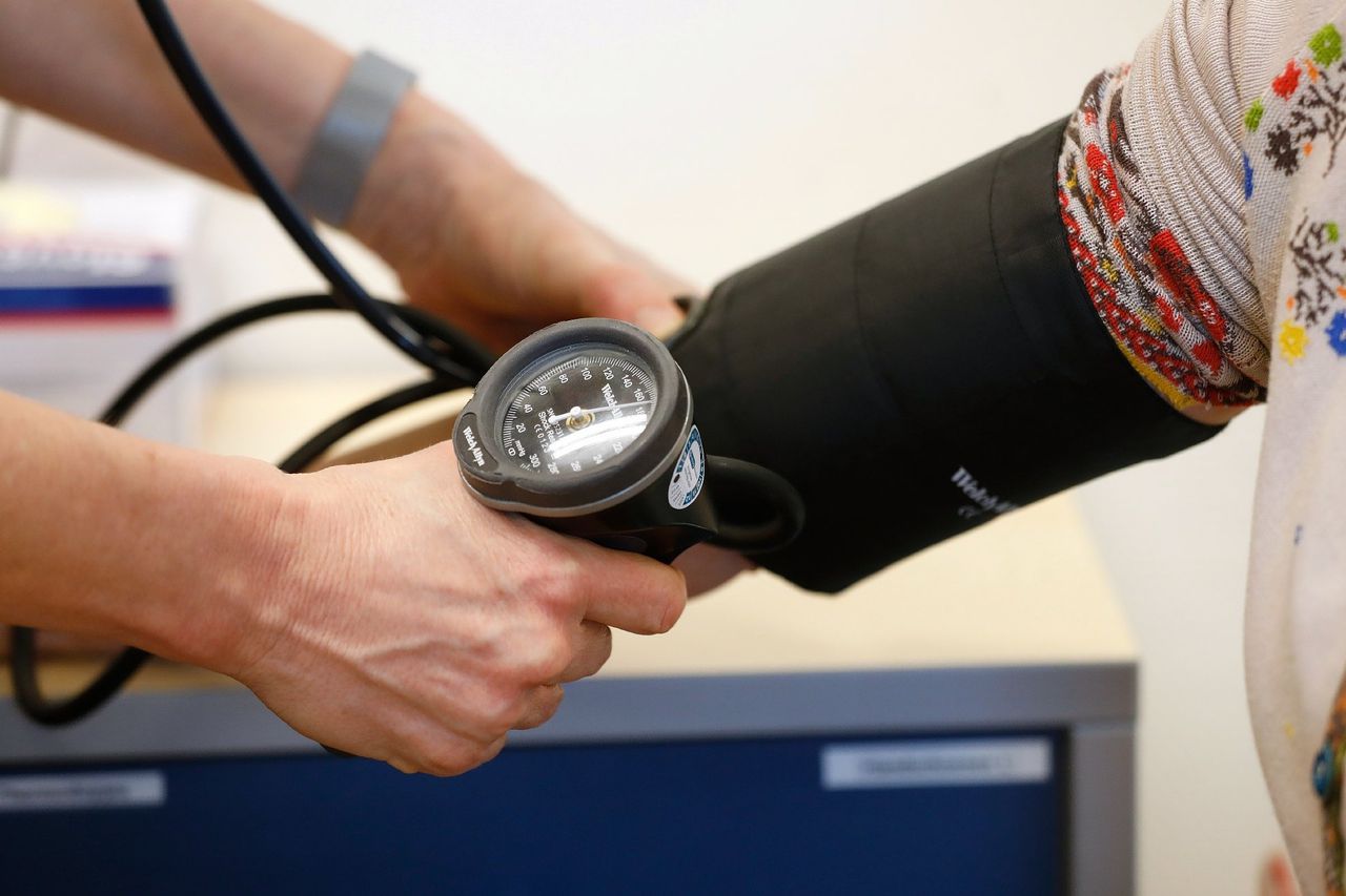 Een huisarts in Gouda meet de bloeddruk van een patiënt