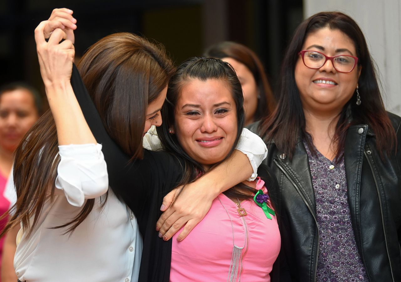 Evelyn Hernández Cruz (midden) viert haar vrijspraak samen met haar advocaten.