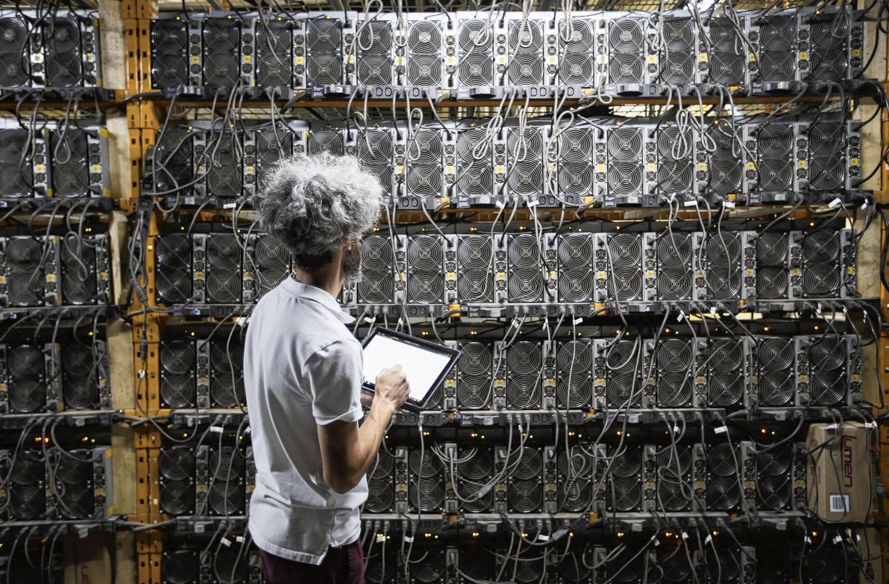 Een medewerker van Canada Computational Unlimited Inc. inspecteert de machines waarmee bitcoin wordt gemijnd.