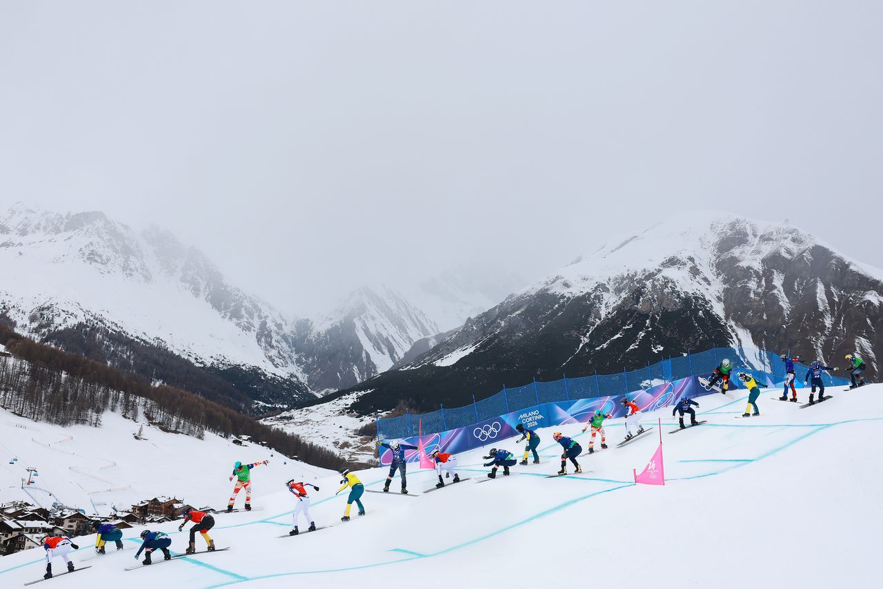 Beeld van de snowboardcross voor mannen, waarbij deelnemers het tegen elkaar opnemen op een hindernissenparcours. 