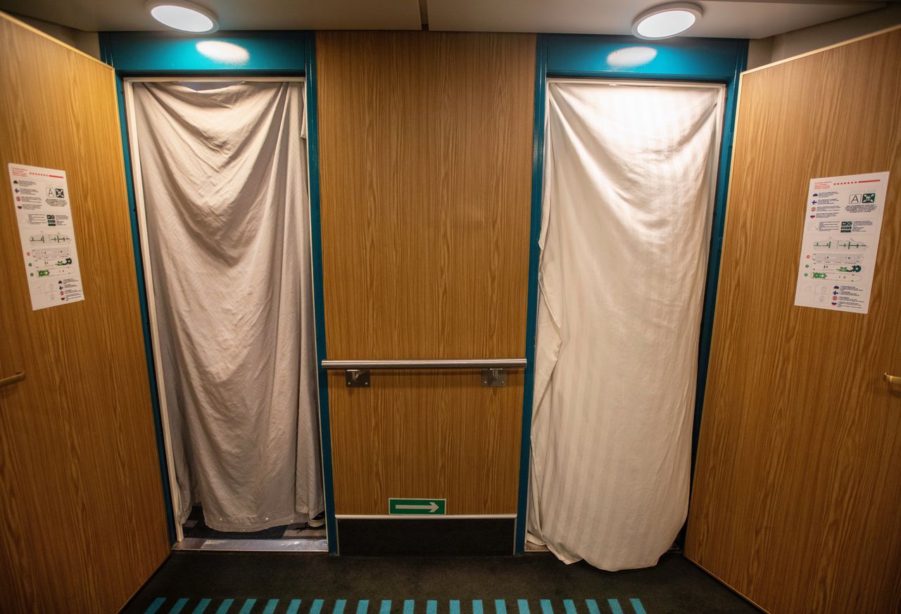 Bewoners hebben lakens voor de deurposten van hun kamers opgehangen.