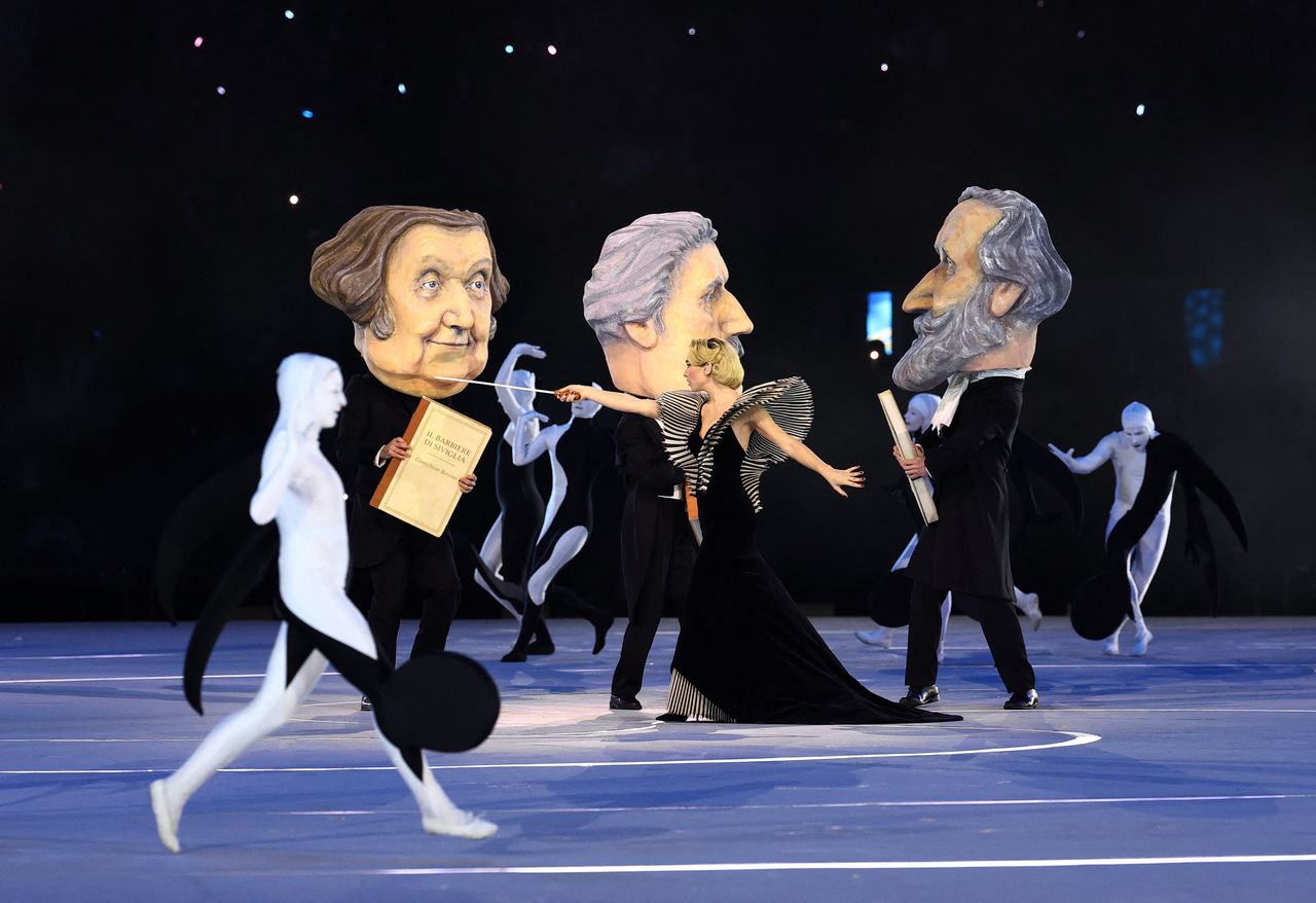 Een optreden van de Italiaanse actrice Matilda De Angelis, samen met dansers met de hoofden van componisten Giuseppe Verdi, Giacomo Puccini en Gioachino Rossini. 