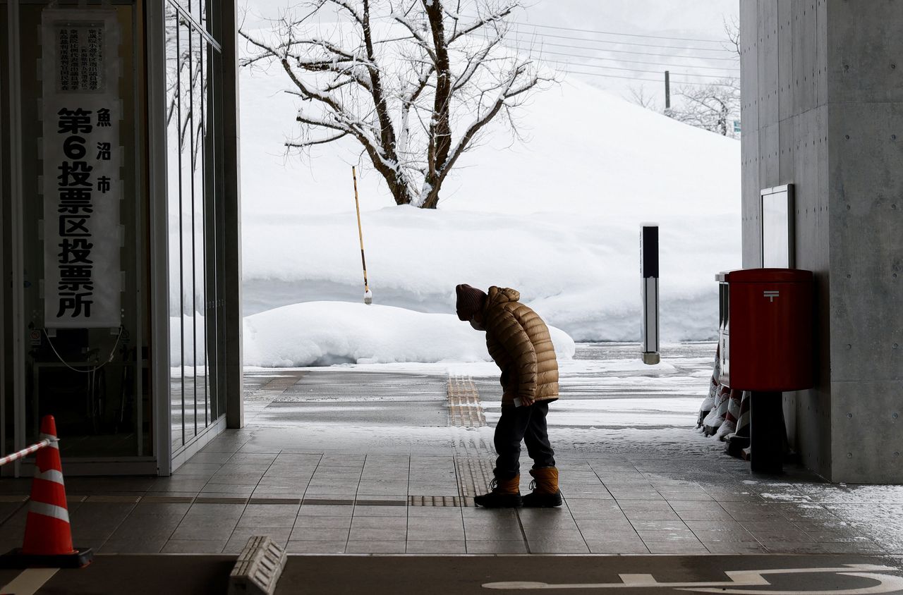 Een kiezer op weg naar het stembureau in Uonuma. 