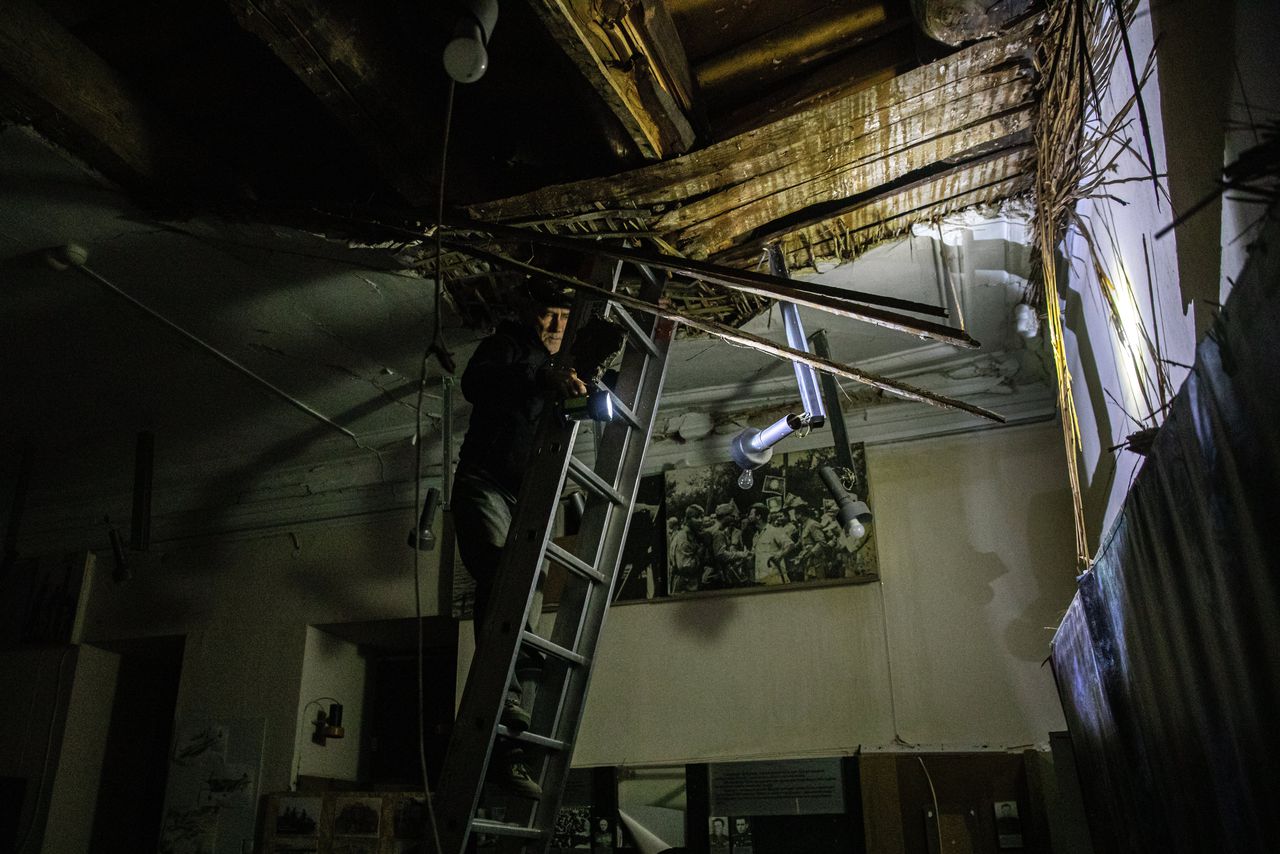 Een medewerker van het Regionale Museum voor Lokale Geschiedenis inspecteert de schade aan het dak na een Russische beschieting. 