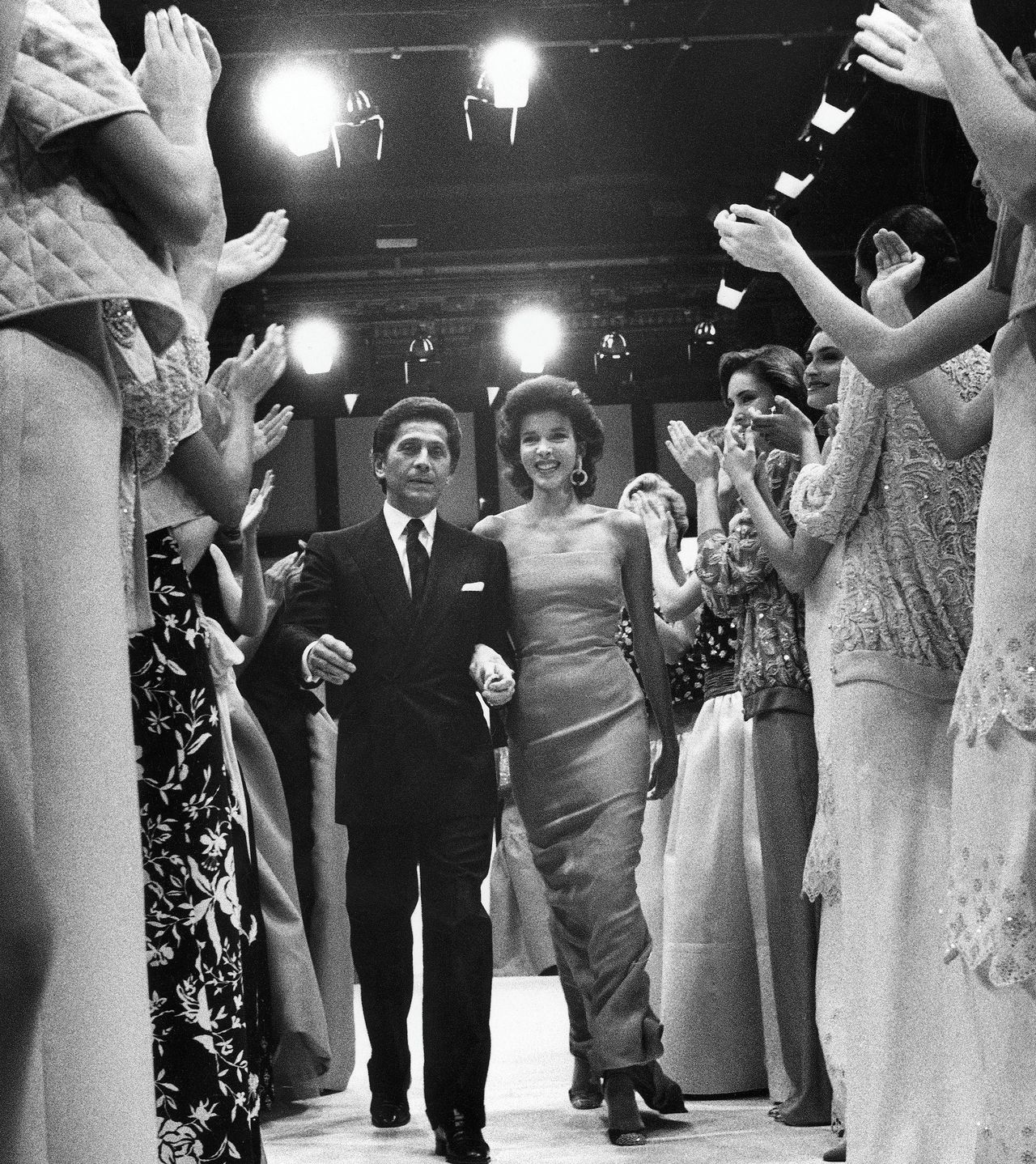 Onder applaus van zijn modellen loopt Valentino Garavani op de modeshow in Rome in 1985. 