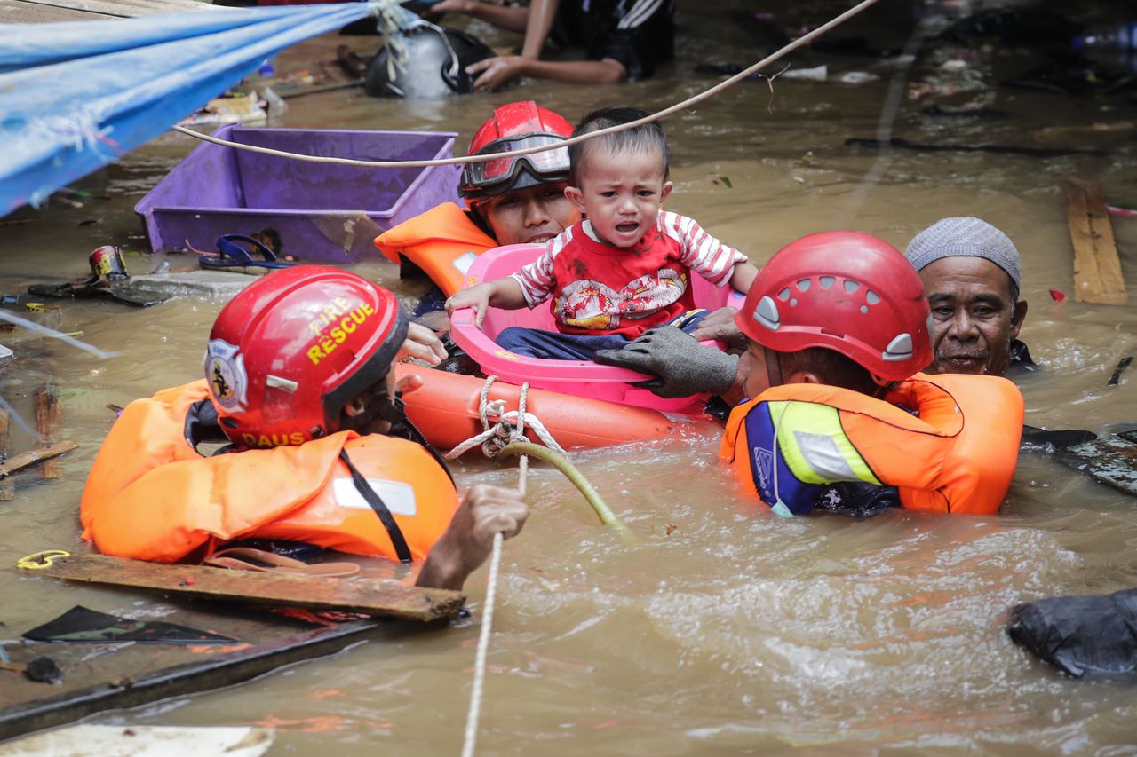 Een kind wordt in Jakarta geëvacueerd.