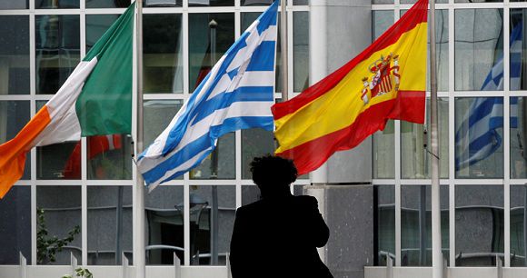 Caption: A pedestrian walks past Irish, Greek and Spanish national flags outside the European Parliament in Brussels August 30, 2011. REUTERS/Francois Lenoir (BELGIUM - Tags: POLITICS)