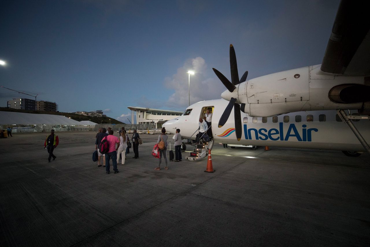 Passagiers stappen uit een toestel van een InselAir dat vanuit Curaçao op Princess Juliana International Airport in Sint Maarten is geland.