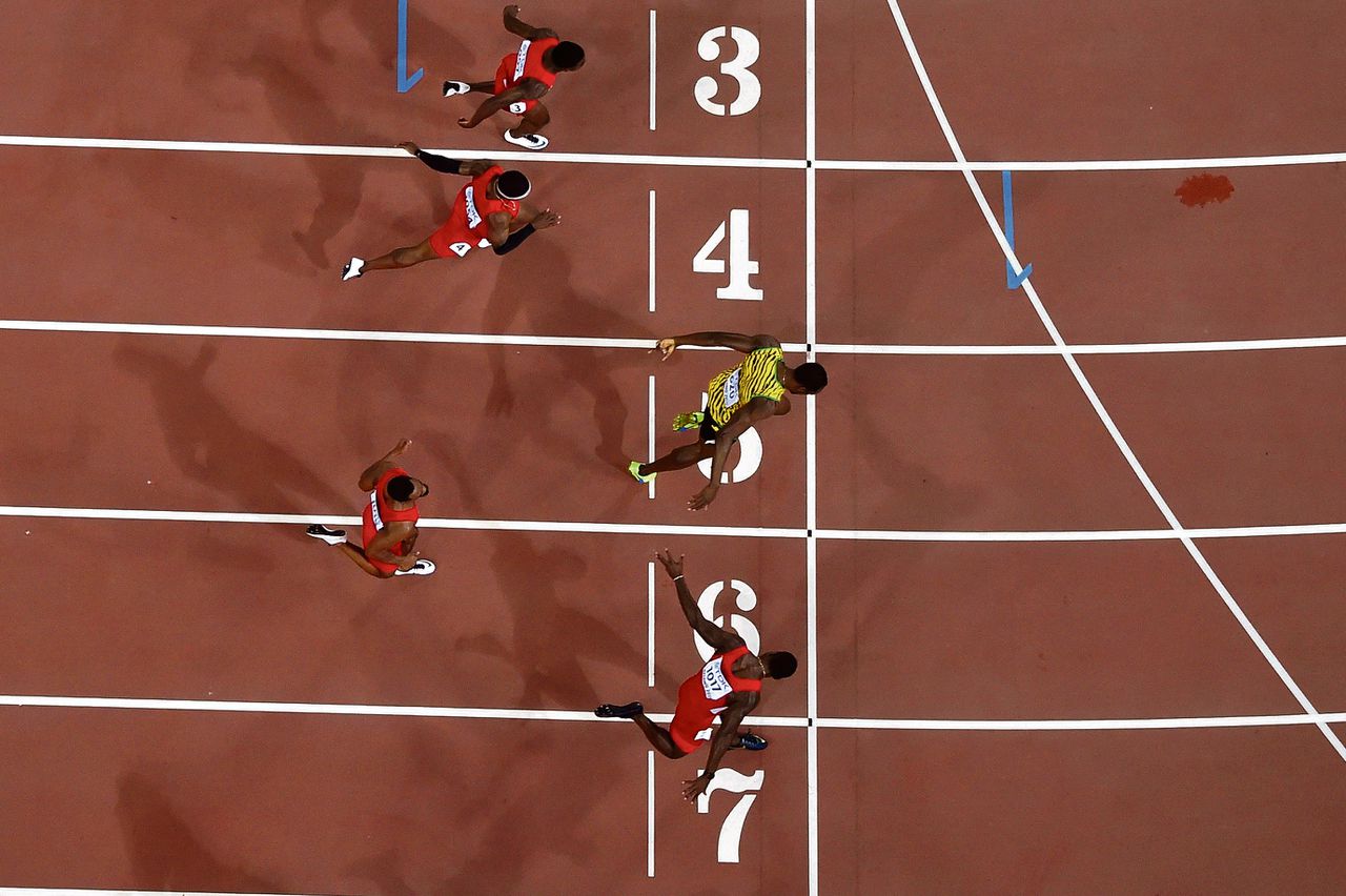Usain Bolt finisht net voor Justin Gatlin in de WK-finale van de 100 meter. Foto Antonin Thuillier/AFP