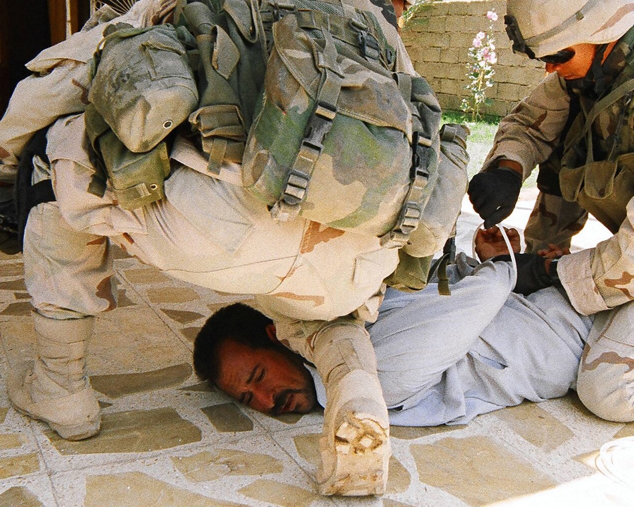 Amerikaanse militairen slaan in 2003 een vermeende rebel in de boeien in de Iraakse stad Ramadi.