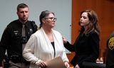Jennifer Crumbley (midden) wordt geleid vanuit de rechtszaal in Michigan. 