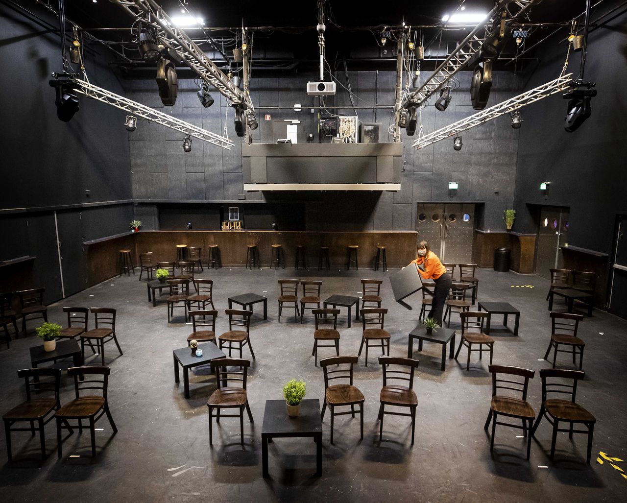 Een medewerker van het Utrechtse poppodium De Helling zet tafels en stoelen klaar voor het eerste concert sinds het begin van de lockdown. Het publiek moet een negatieve coronatest laten zien .