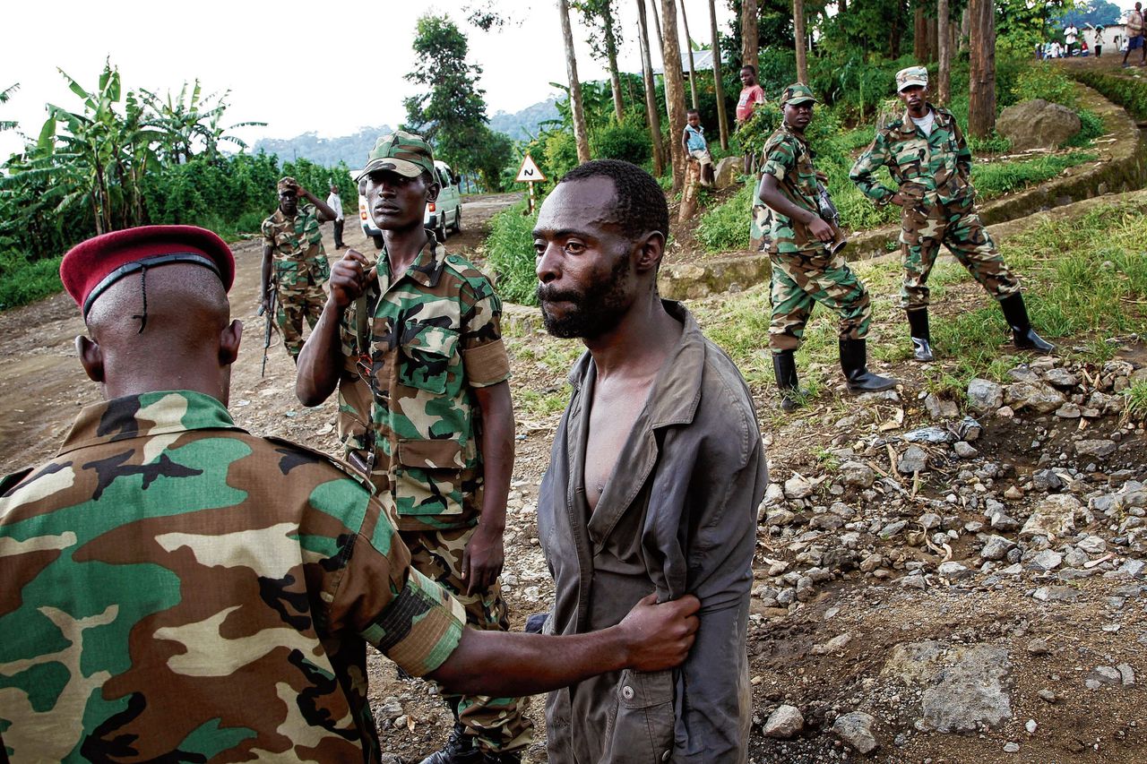 Congolese rebellen houden in 2012 ten noorden van de stad Goma een man aan, die ze ervan verdenken voor een Rwandese militie te werken.