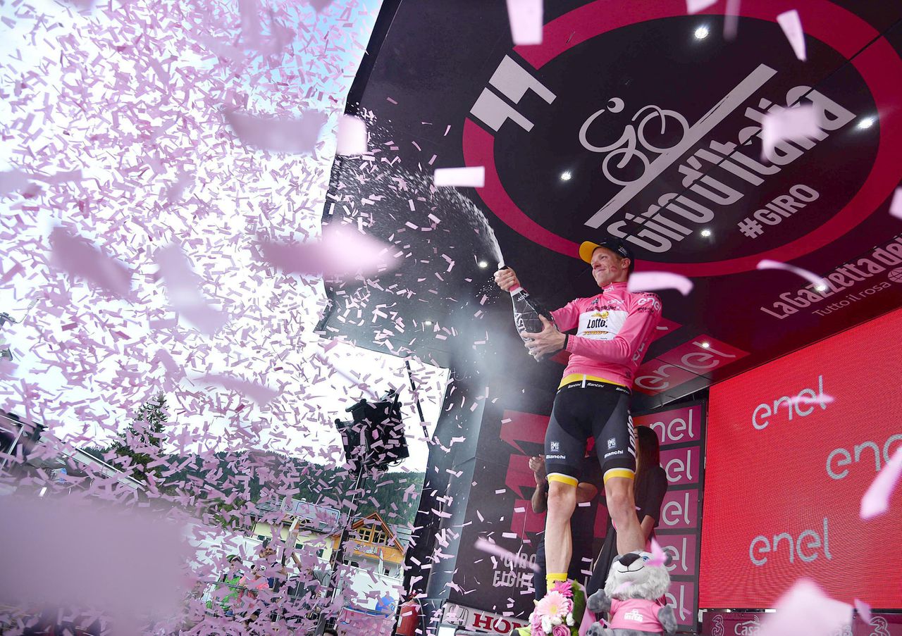 Steven Kruijswijk ontkurkt in de roze trui de champagne nadat hij in de 16e etappe van de Giro zijn leiding in het klassement heeft verstevigd.