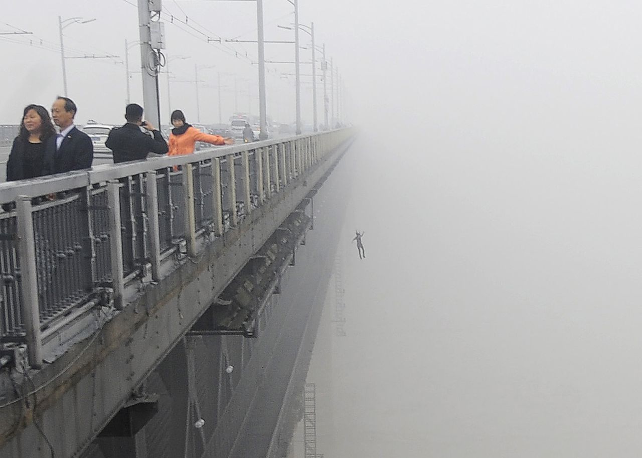 Op deze foto uit 2013 springt een jonge man van de brug over de Yangtze in Wuhan.  Foto China Out / AFP