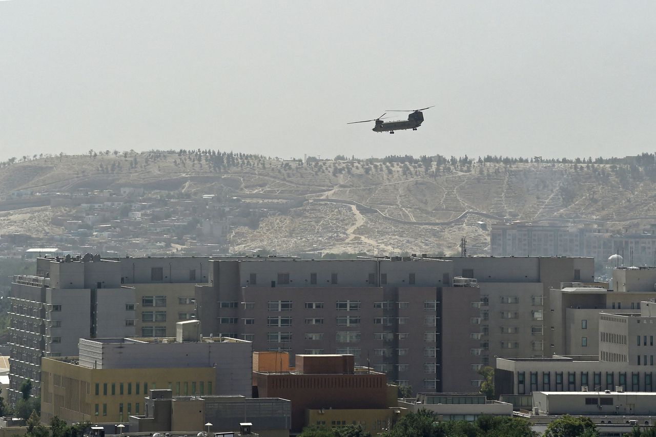Een Amerikaanse helikopter vliegt boven de ambassade in Kabul, waar personeel sinds zondag wordt geëvacueerd.