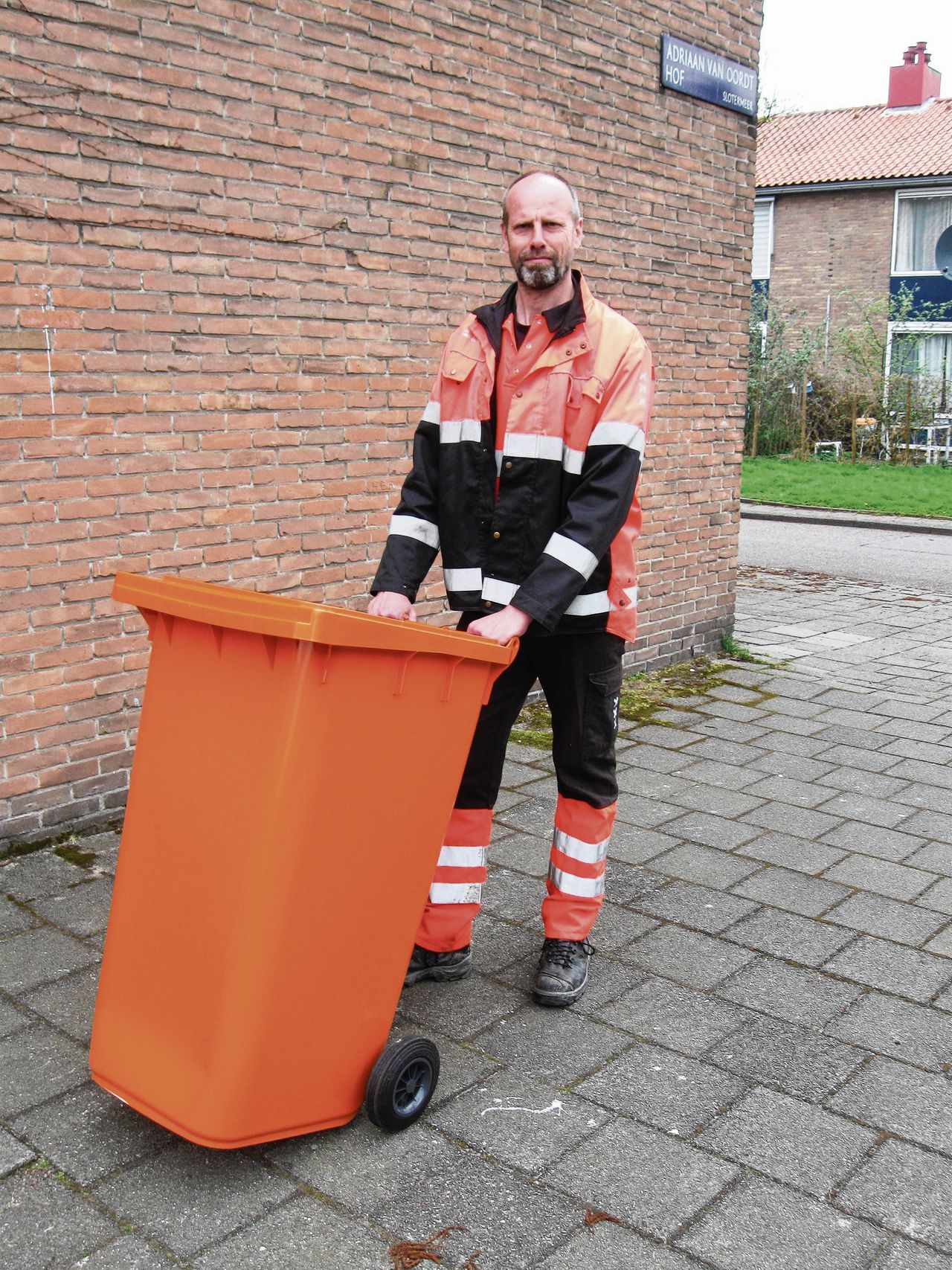 Arnout Schaap, links in zijn vuilnismannen-tenue, waarin hij op scholen lesgeeft over afval en recycling.