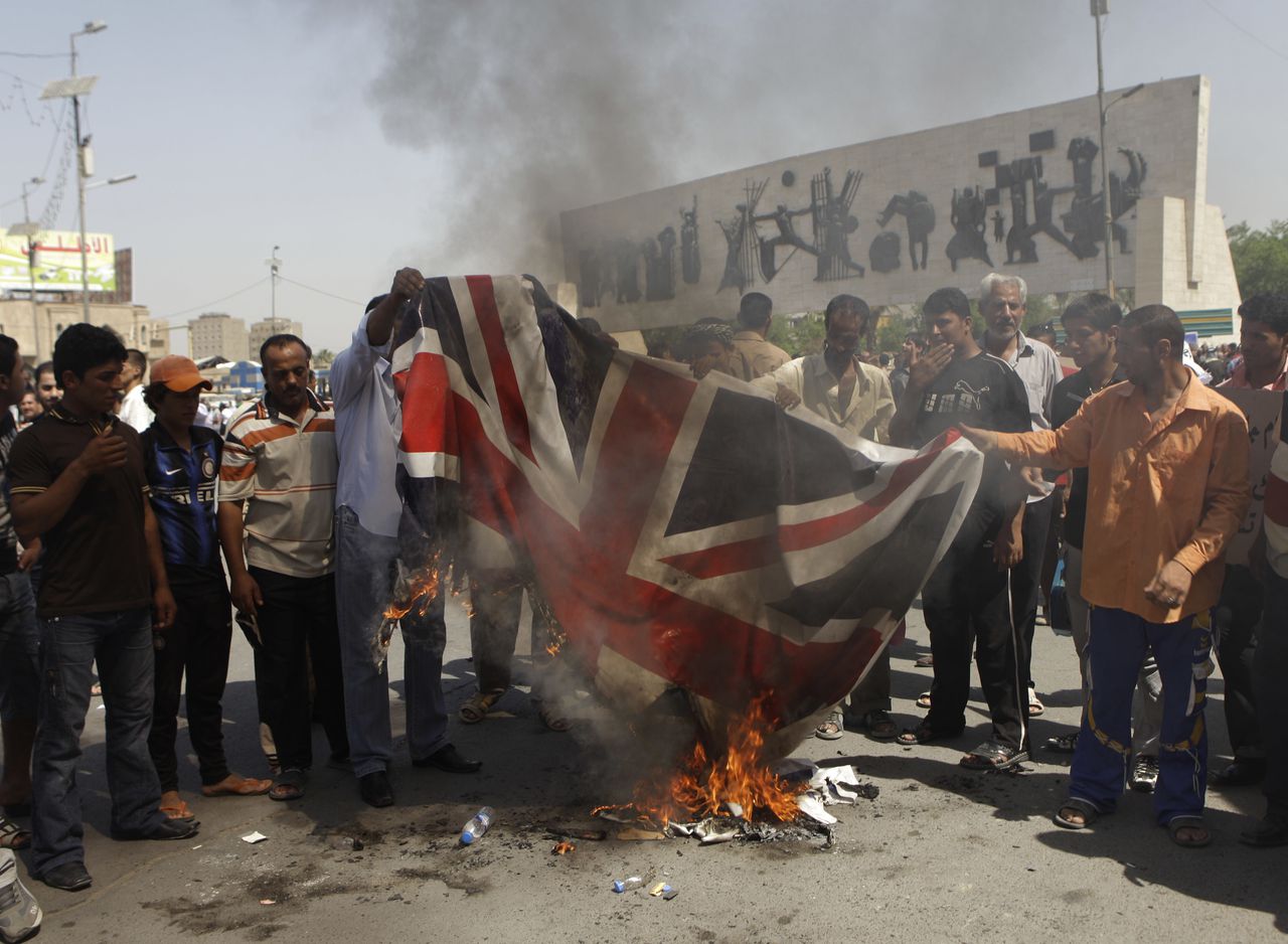 Demonstranten verbrandden een Britse vlag op het Tahrir plein in Bagdad op 9 september 2011 uit protest tegen de dood van de 26-jarige Baha Mousa die op datzelfde plein werd gedood in 2003.