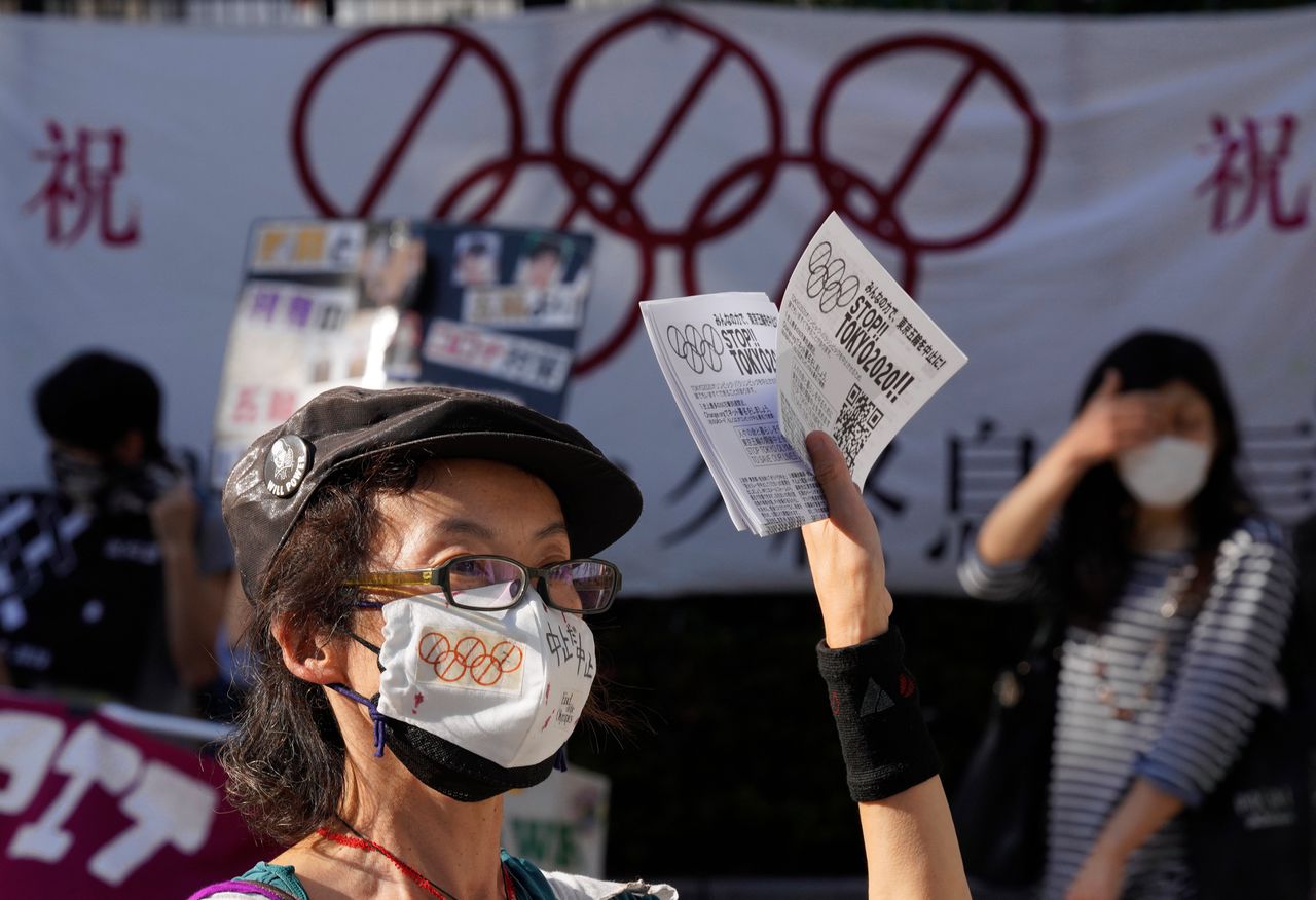 Een demonstrant tegen de Olympische Spelen in Tokio deelt op 23 mei pamfletten uit in de Japanse hoofdstad.