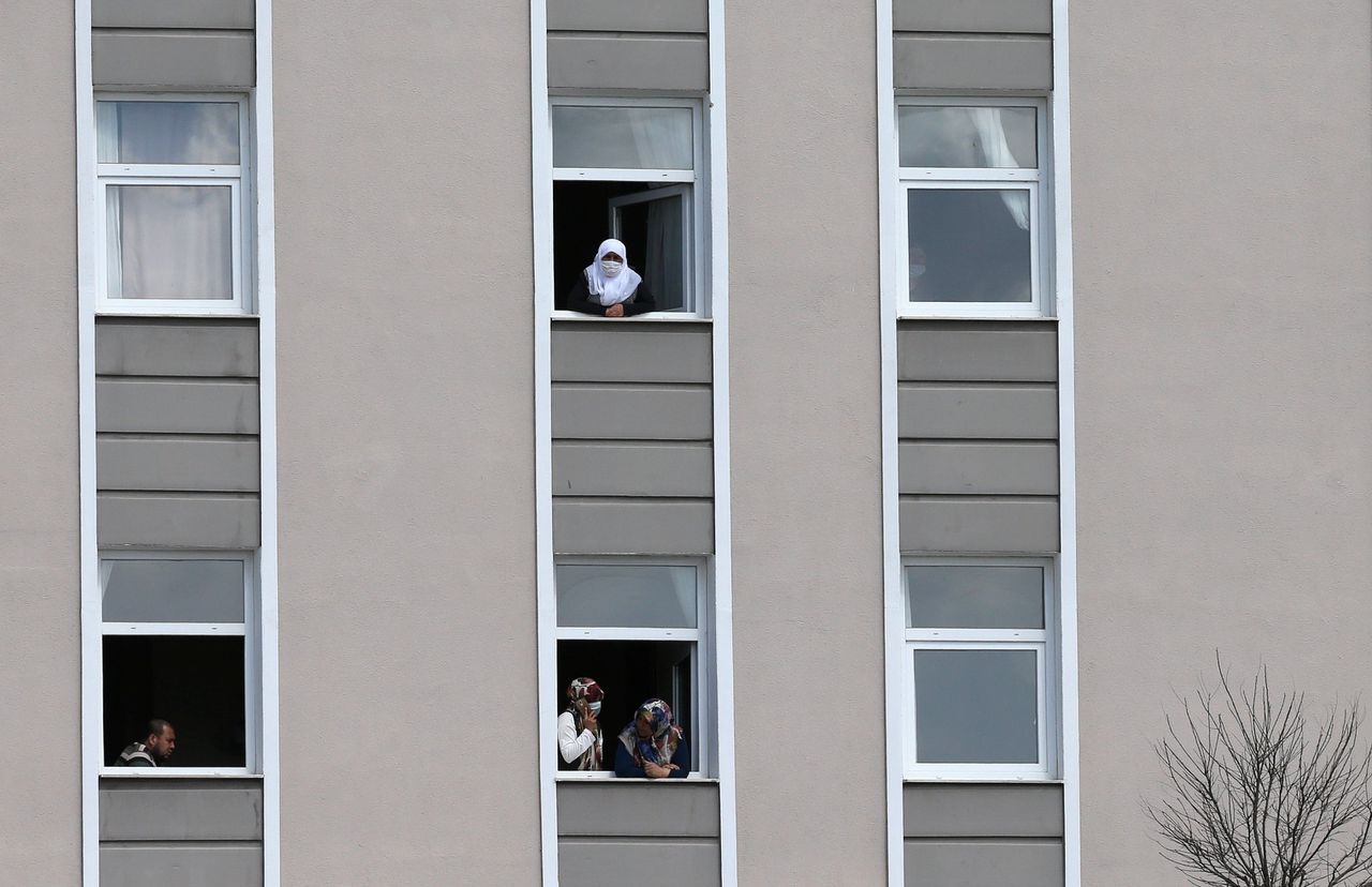 Pelgrims die op bedevaart zijn geweest in Saoedi-Arabië kijken uit het raam van een gebouw in Ankara waar ze in quarantaine zijn geplaatst.