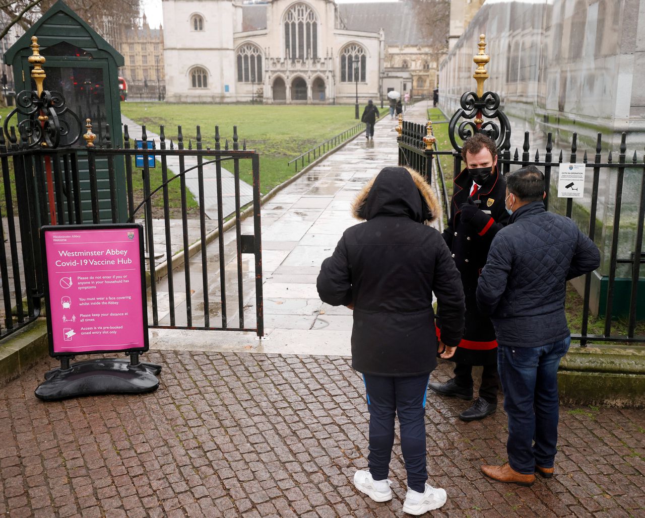 Patiënten worden begroet door Abbey-personeel buiten een vaccinatiecentrum in Westminster Abbey