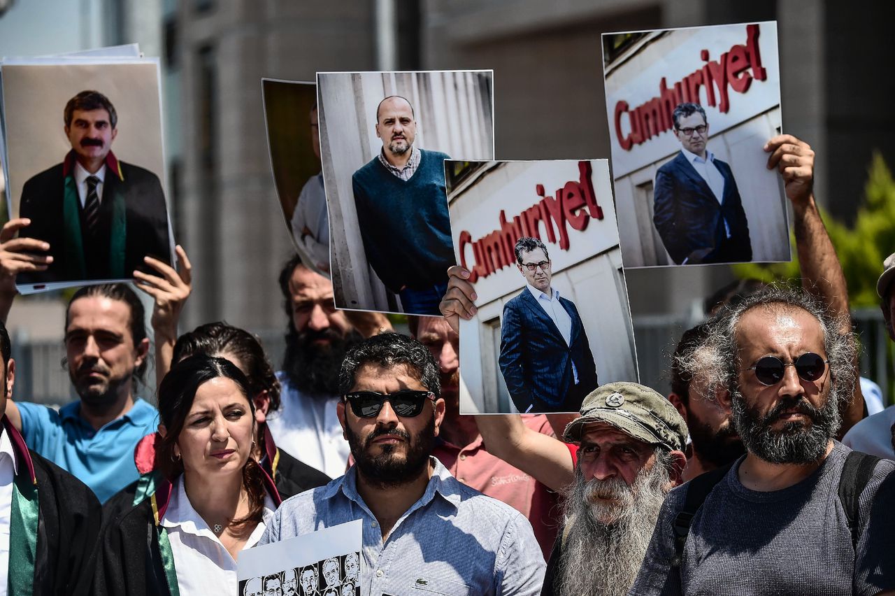 Journalisten en activisten houden op 25 juli 2017 foto's vast van gevangen gezette journalisten tijdens een demonstratie voor de rechtbank in Istanbul.