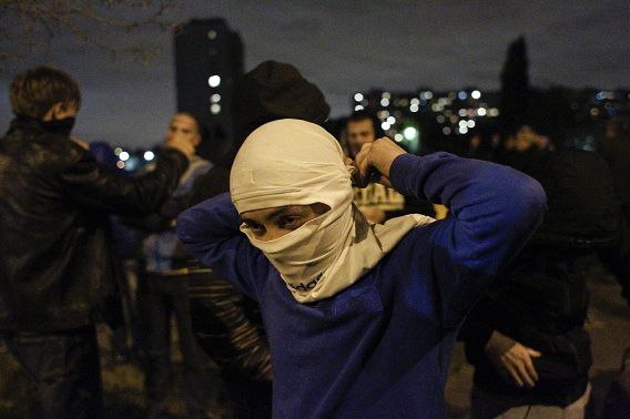 Een man doet een masker op tijdens het uit de hand gelopen protest gisteren in Biryulyovo, Moskou.