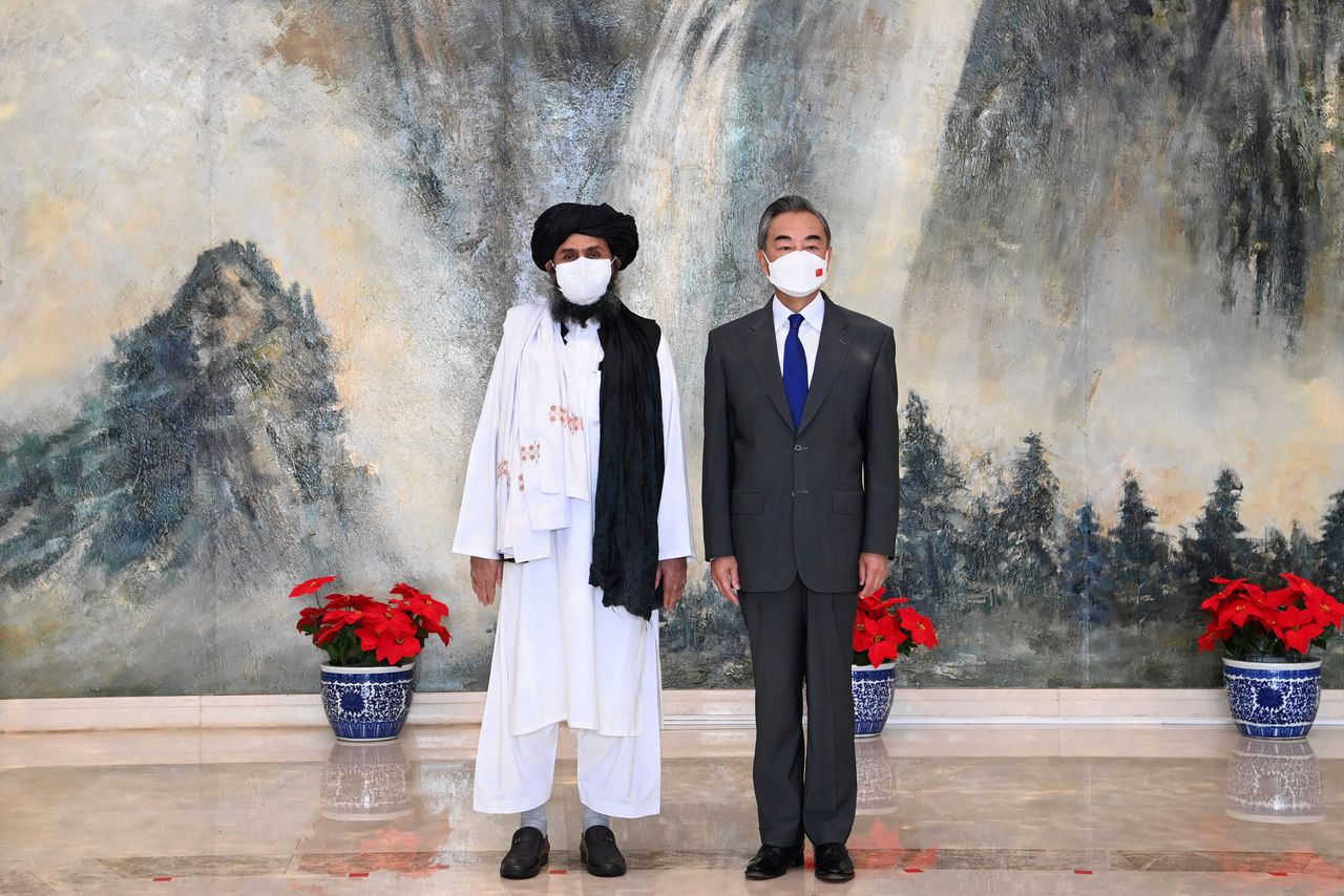 Beeld van medeoprichter Mullah Abdul Ghani Baradar van de Taliban links en Wang Yi, buitenlandminister van China, rechts bij een ontmoeting in juli.