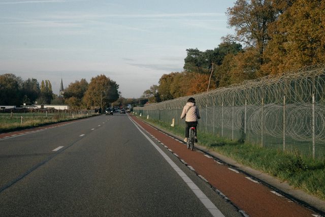 Een fietser rijdt langs de militaire basis Kleine-Brogel. 