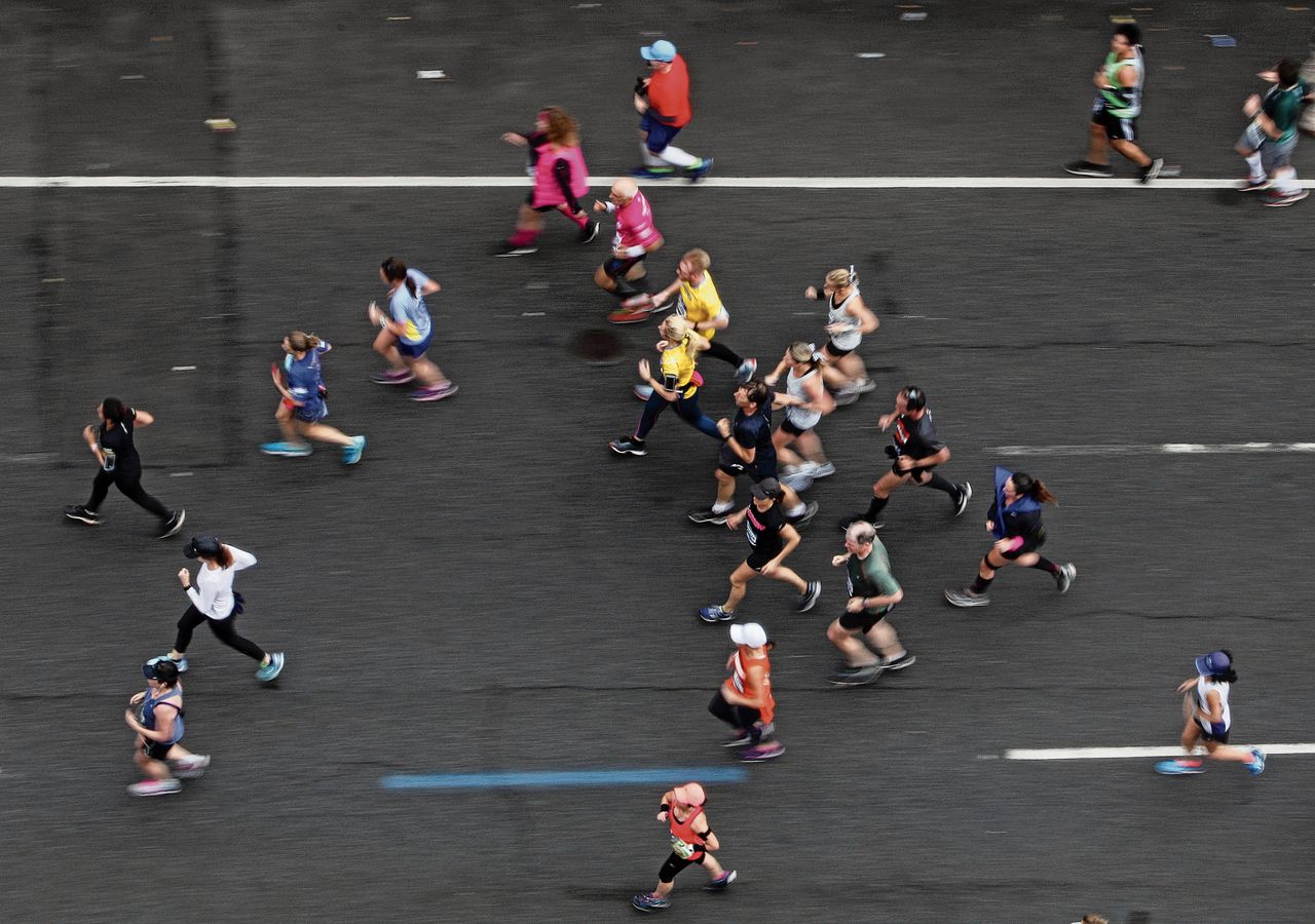 Lopers tijdens de marathon van New York . Een methode om mensen met minder training zo’n afstand te laten lopen, is controversieel.