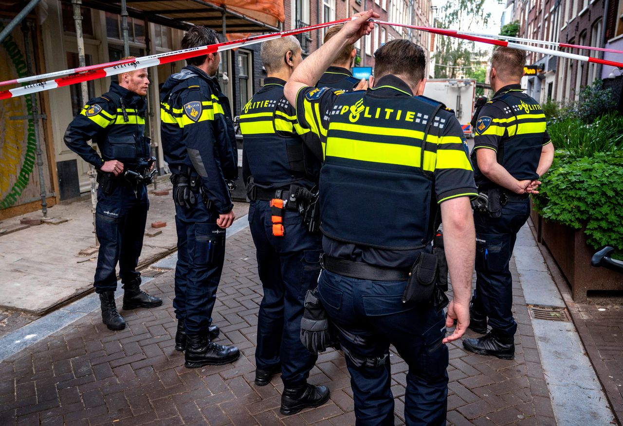 Agenten bij de Lange Leidsedwarsstraat, die werd afgezet na de schietpartij waarbij Peter R. de Vries dinsdagavond ernstig gewond raakte.