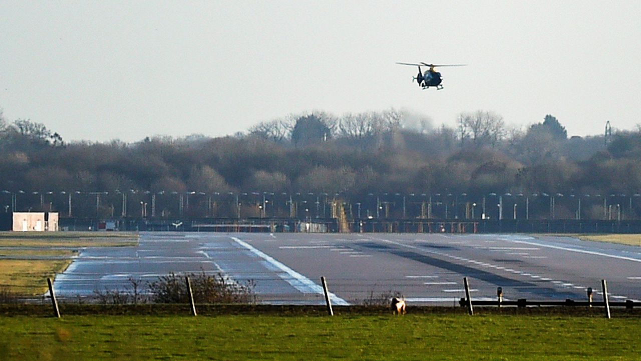Een politiehelikopter vliegt over de luchthaven.
