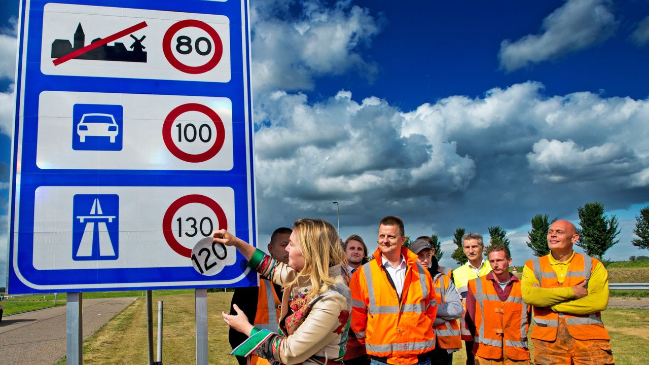 Minister van Verkeer Melanie Schultz van Haegen (links) onthult het 130 kilometerbord bij de grensovergang Zandvliet aan de A4.