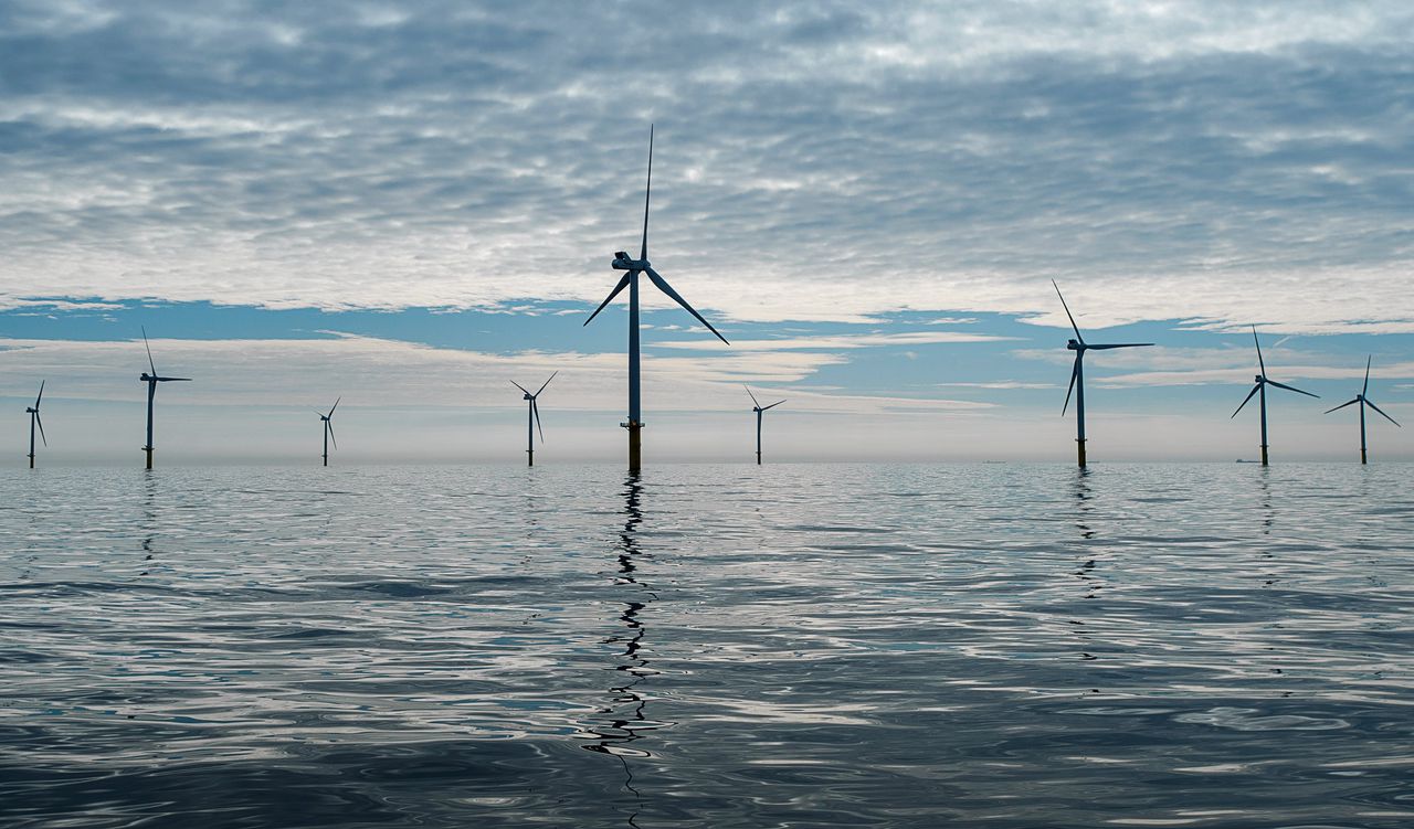Windmolens reiken boven het wateroppervlakte van de Noordzee. De windmolens zijn onderdeel van windpark Luchterduinen.