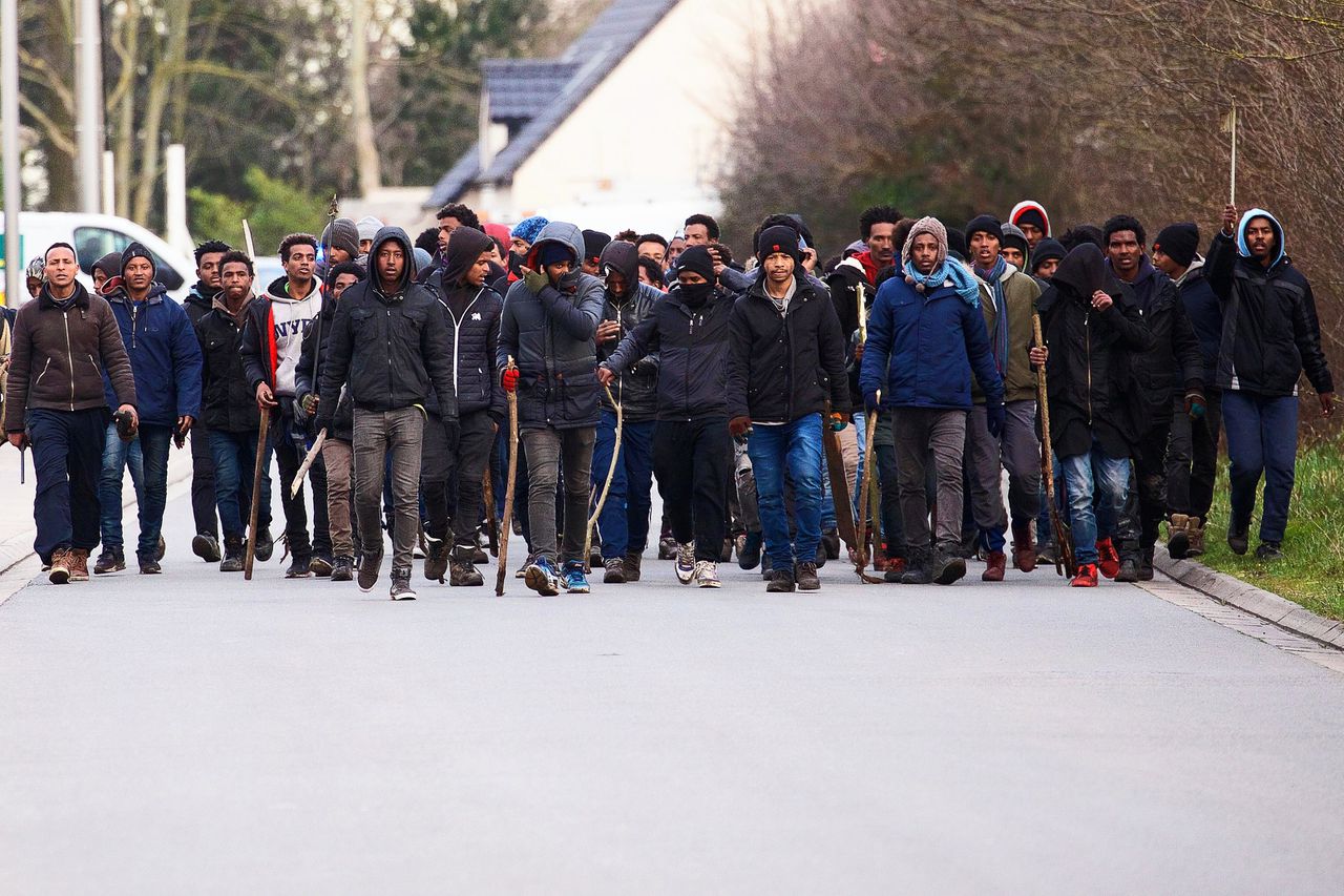 Een groep met stokken en stenen bewapende migranten bij de vechtpartijen in Calais.